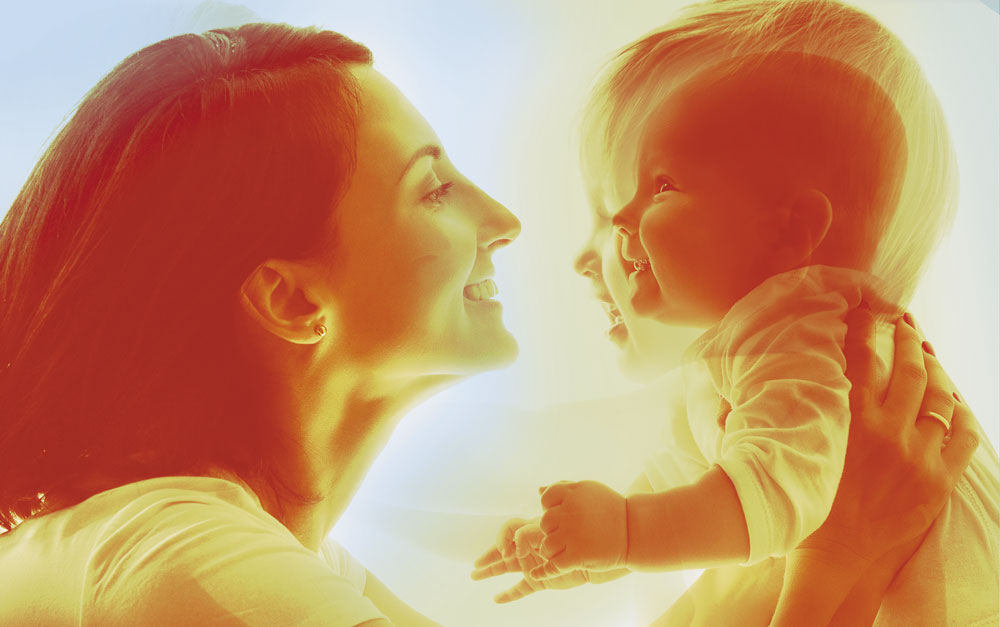 Woman holding a child shown at two ages, infant and toddler, superimposed on one another