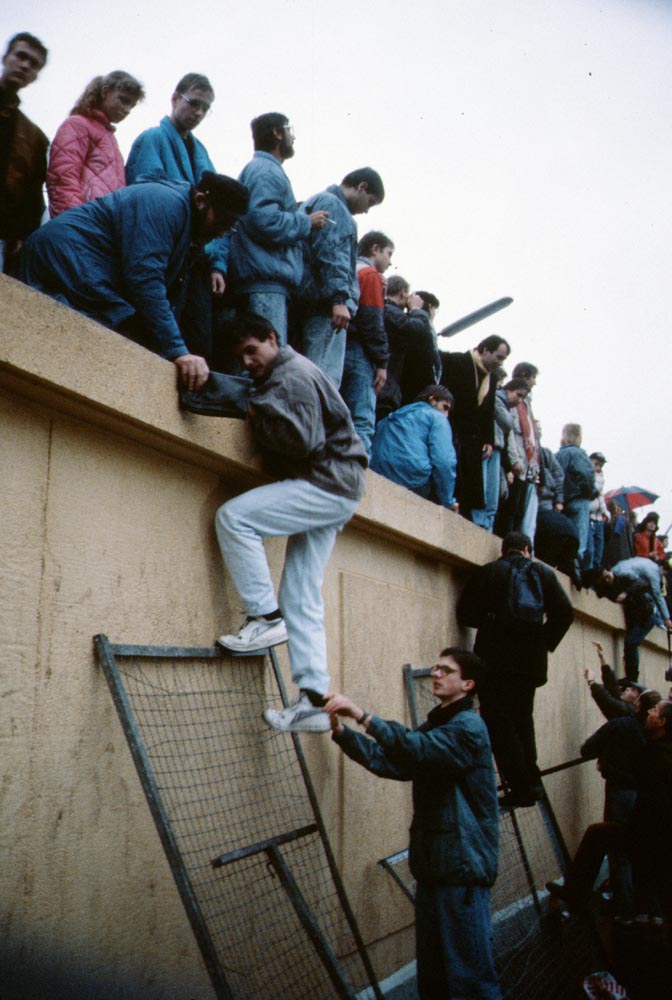 People climbing the Berlin Wall