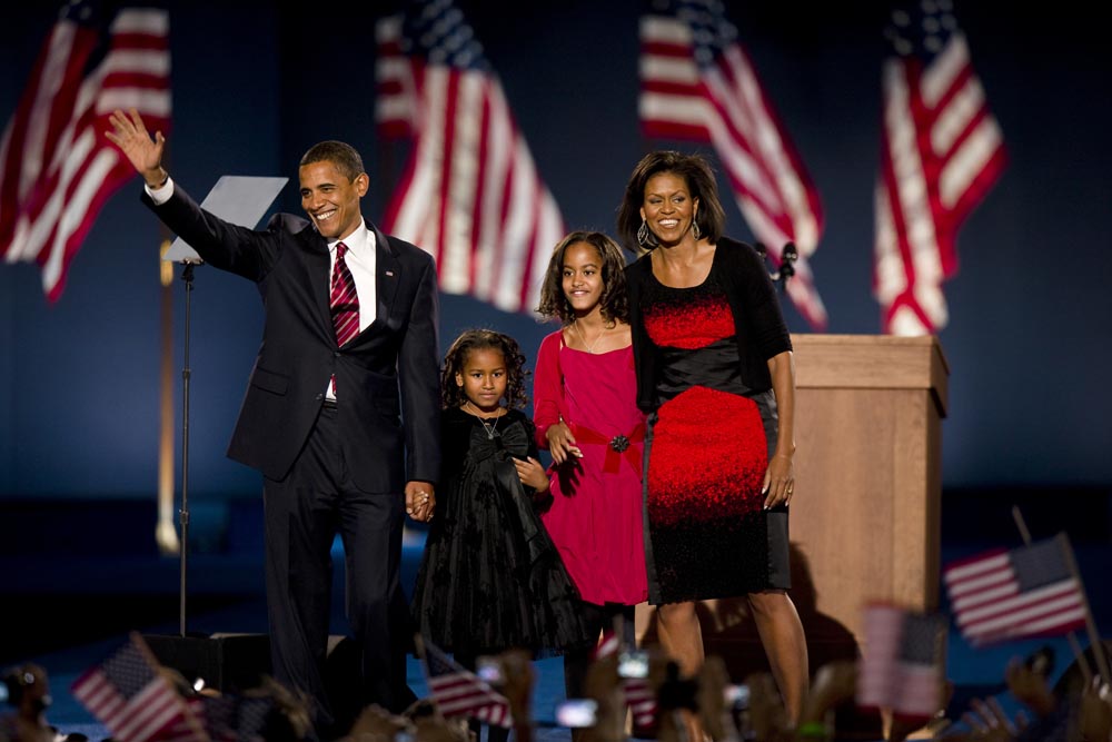 Barack Obama waves, accompanied by his family