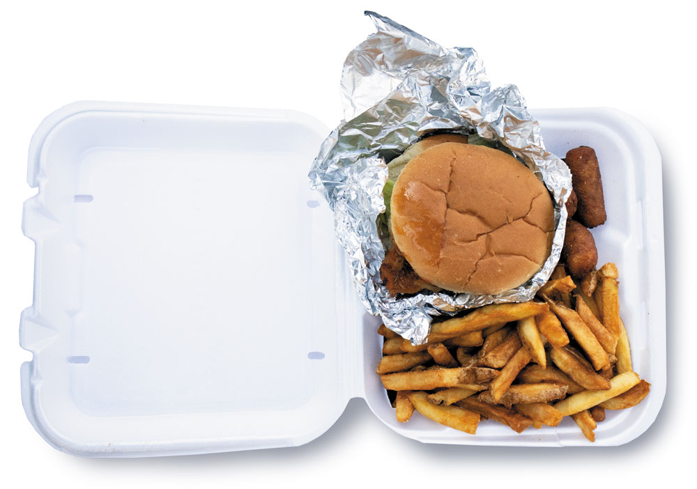 A to-go box from Cook Out with a sandwich and fries