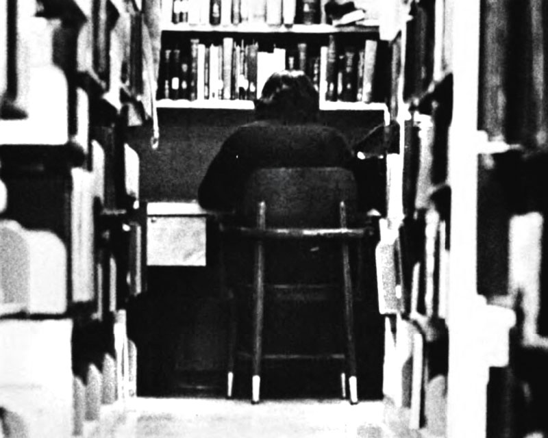Black-and-white photo of a student in a study carrel