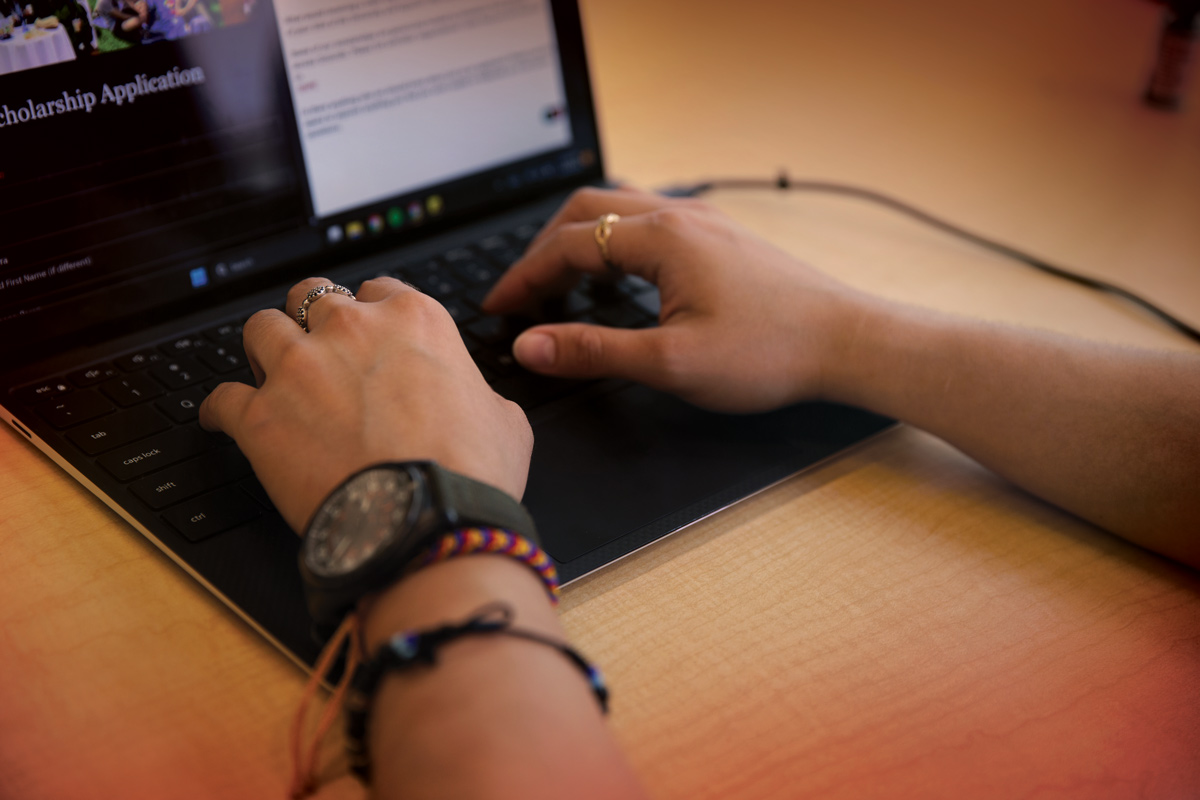Hands typing at laptop