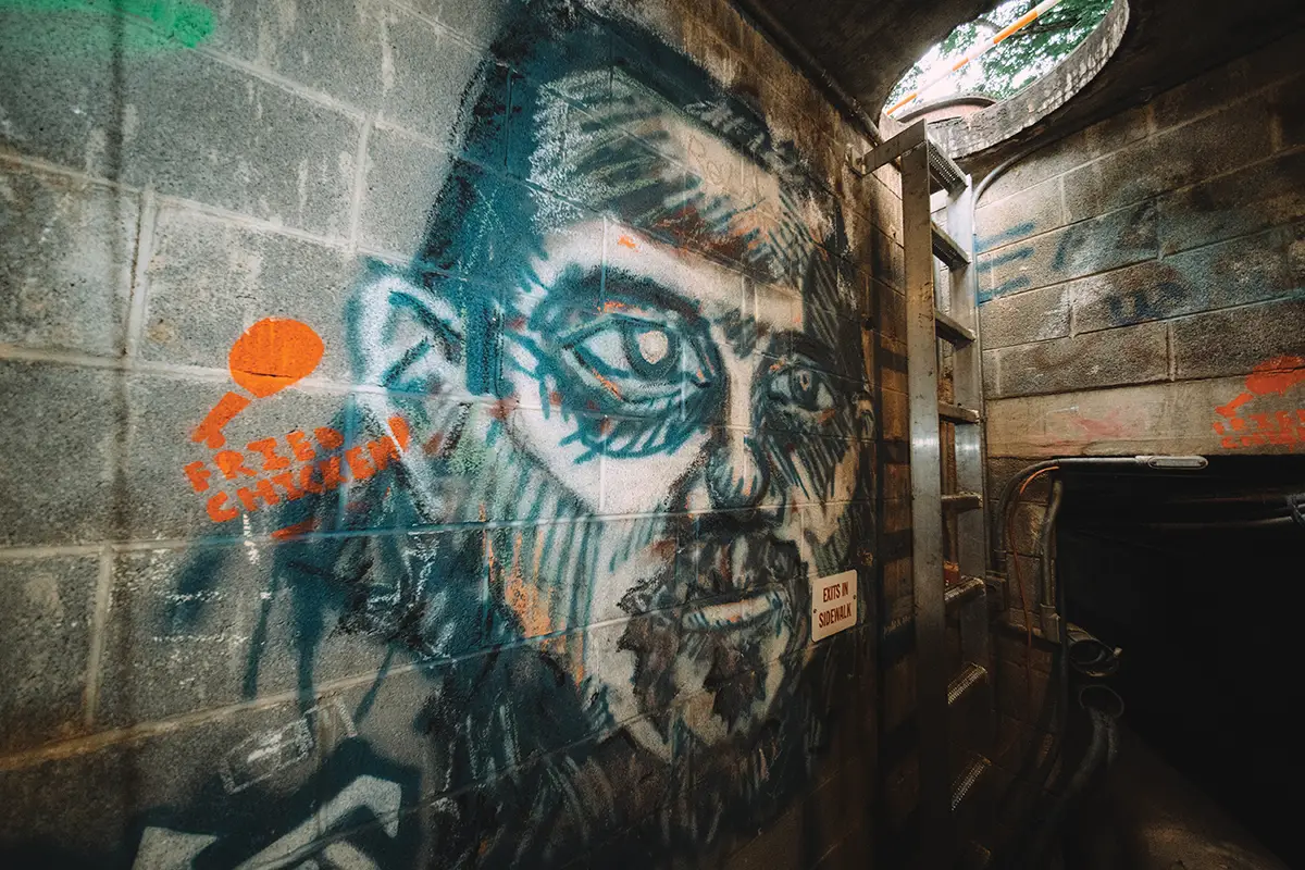 Graffiti portrait inside steam tunnels under UVA Grounds